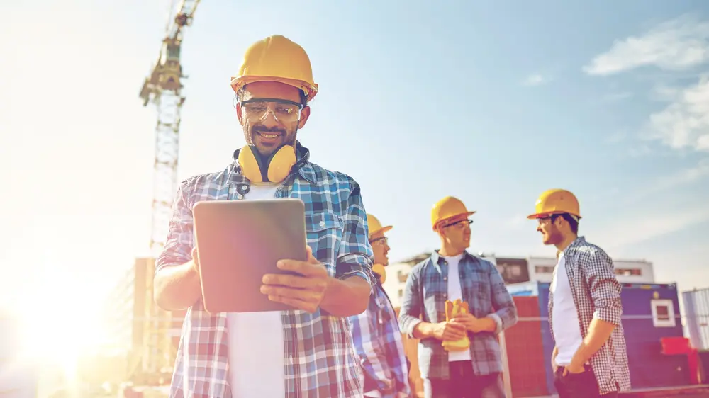 © Syda Productions / Adobe Stock Baufachkraft mit Helm und Tablet auf einer Baustelle