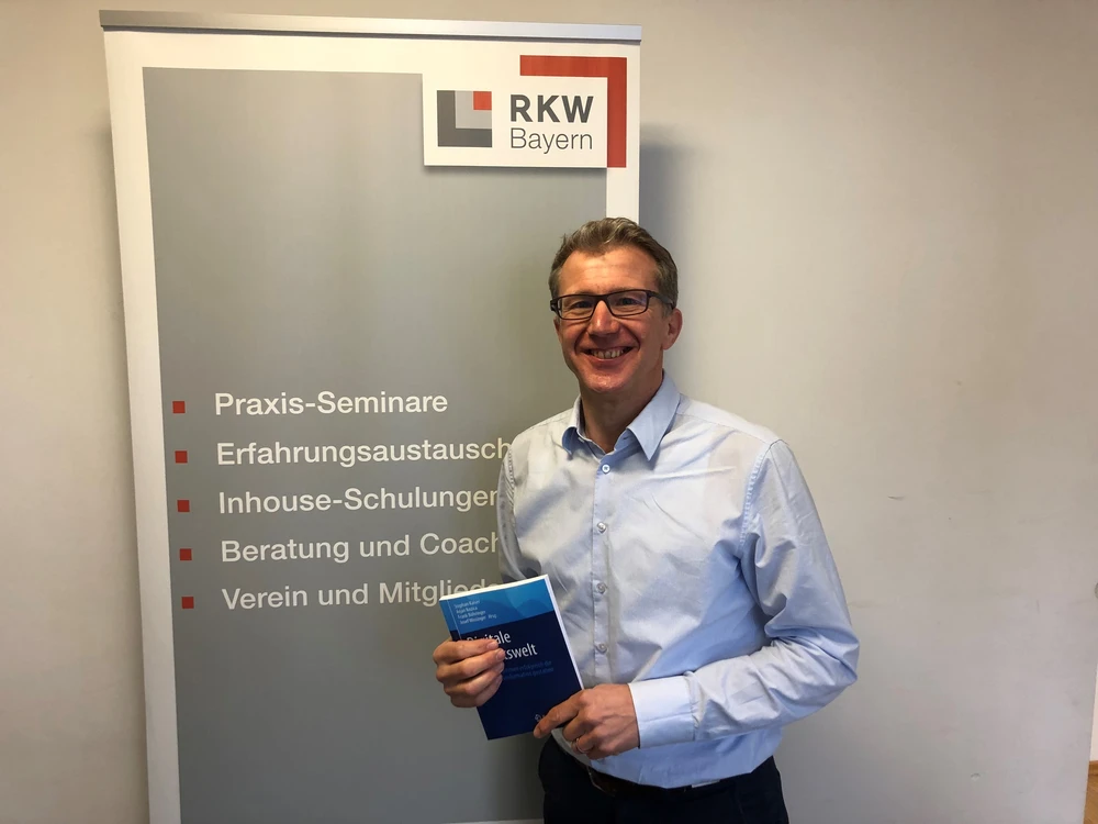 © D. Norridge / RKW Bayern e. V. Herausgeber zeigt sein Buch zur Digitalen Arbeitswelt
