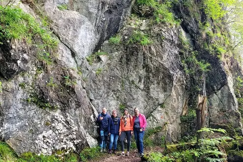 Das RKW Team auf einer Wanderung vor hohen Felsen